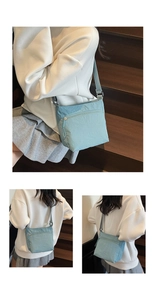 Detail of light blue washed canvas crossbody bag with adjustable strap and zip pocket