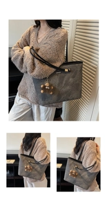 Close-up of grey tote bag with matte texture, metallic zipper, and a plush doll charm