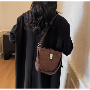 Brown retro bucket bag with quilted stitching details shown in a lifestyle back view