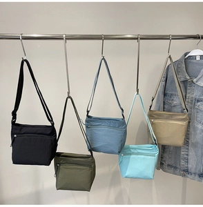Detail view of colorful nylon crossbody bags with functional front zipper pockets