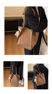 Detail of a brown lychee pattern tote bag with knot strap and cute plush bear charm
