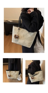 Detail of green stone pattern tote bag with plush monster charm and black handles