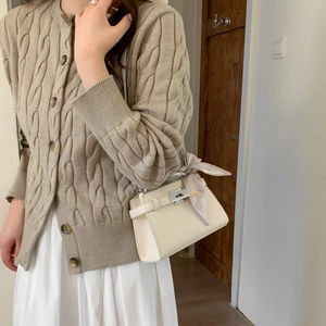 Chic cream crossbody bag with silver lock and silk scarf detail worn with knit cardigan