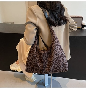 Detail view of the retro leopard print hobo bag with black leather strap on a model shoulder