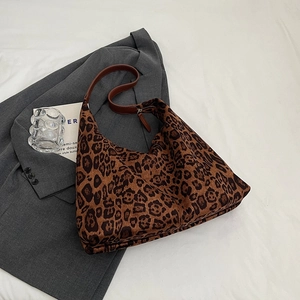 Detail of leopard print hobo bag texture on a grey blazer with stylish props