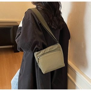 Close-up of olive green crossbody bag made of durable nylon with wide strap