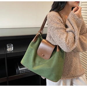 Detail of dark green large tote bag with brown leather straps and vintage canvas texture