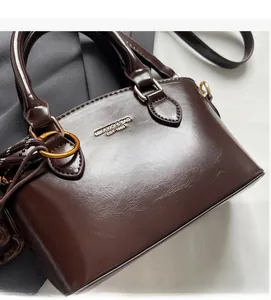 Detailed macro view of dark brown glossy leather texture with golden metal hardware