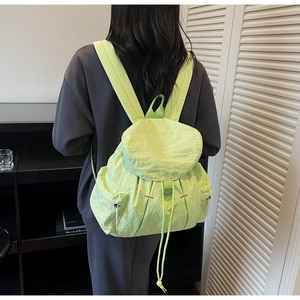 Detalle de la mochila verde neón con textura de tela de nailon arrugado resistente al agua