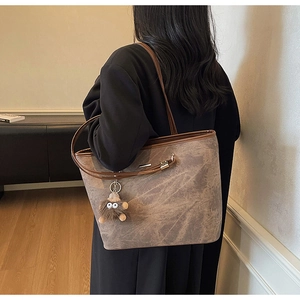 Detailed back view of large autumn tote bag with marble print and plush monster charm