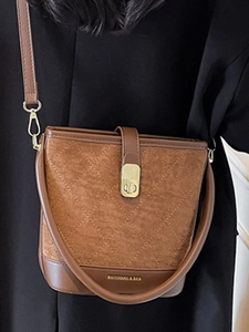 Brown suede bucket bag with quilted patterns and leather sides shown on a model