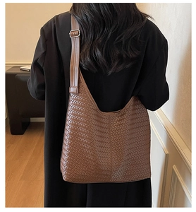 Gros plan sur un cabas tressé marron avec texture croisée et bandoulière réglable