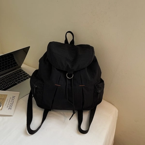 Vista detallada de la mochila de nailon negro con solapa y bolsillos con cremallera