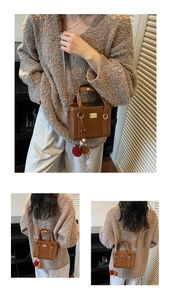 Detail view of brown leather bucket bag with gold hardware and plush pom-poms charms