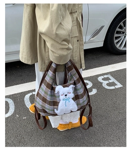 Detail of checkered plaid tote bag with cute dog patch and blue embroidery