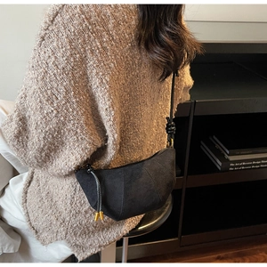 Dettaglio della borsa a mezzaluna in camoscio nero con texture e fibbia in oro lucido