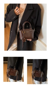 Detail view of a vintage dark brown mini tote bag with logo lettering and charm