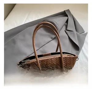 Detailed shot of brown woven leather handbag handle with colorful beaded charm