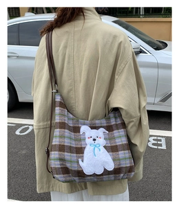 Detail of checkered tote bag featuring a cute white dog embroidery and dark brown strap