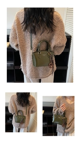 Detail view of olive green mini tote bag with glossy finish and tassels on a model