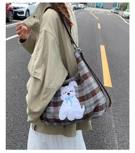 Detail of retro plaid tote bag with cute white puppy embroidery patch and brown strap