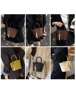 Detailed view of woven leather tote bags in various colors with bead tassel decor