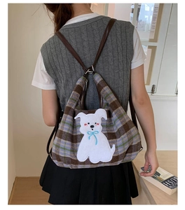 Close-up of the plush checkered tote bag featuring a cute white puppy embroidery patch