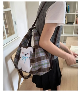 Plaid tote bag with white cartoon puppy patch shown in a cozy study room setting