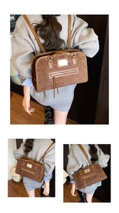 Detailed view of brown retro underarm bag with matte suede texture and gold logo plate