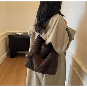 Détail du grand sac cabas en daim marron foncé avec logo et pochette assortie