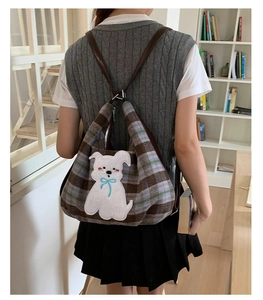 Detail of plaid tote bag featuring a cute white dog embroidery patch and leather straps