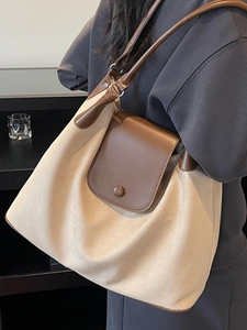 Minimalist beige canvas and brown leather tote bag for daily commute and travel