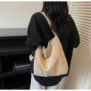 Détail d'un grand cabas en daim blanc cassé avec une mini pochette et une texture souple