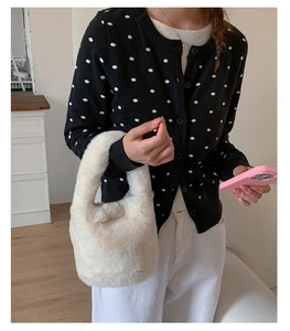 Close-up of fluffy white plush bucket bag with soft faux fur texture and top handle