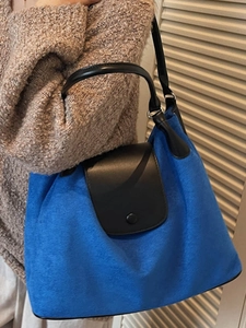 Electric blue wool tote bag with black leather straps shown on model for daily commuting
