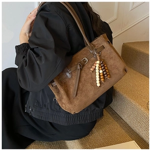 Vista dettagliata della borsa tote in pelle scamosciata marrone con fibbia in metallo