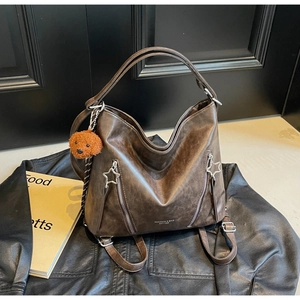 Detail of dark brown retro PU leather texture and star zipper on a versatile backpack