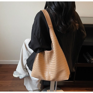 Vue détaillée de la texture tissée du sac fourre-tout marron et du design hobo