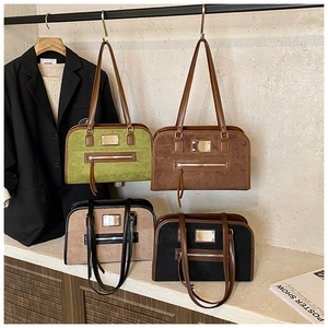 Detail view of retro suede tote bags in green, caramel, beige, and black with metal plaque