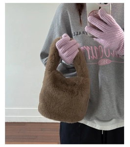 Detail view of brown plush bucket bag showing fluffy faux fur texture and integrated handle