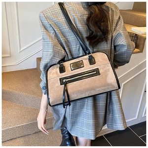 Retro beige suede underarm bag with black leather trim worn with a grey blazer