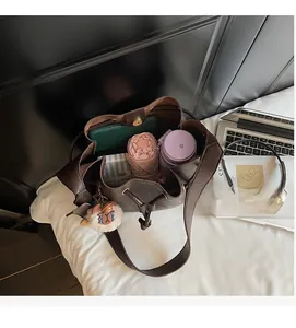 Interior view showing the large capacity of the brown leather bucket bag with items