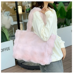 Detalle del bolso tote de piel sintética rosa con textura suave y correa ancha para el hombro