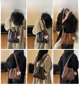 Detail view of stylish dark brown faux leather bucket bag with plush tiger charm