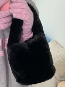 Fuzzy black faux fur bucket bag with plush texture and stylish handheld carry handle