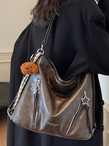 Retro dark brown leather tote bag with star zipper and cute bear pendant on a model