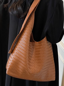 Sac fourre-tout hobo en cuir tressé marron pour femme porté par un mannequin