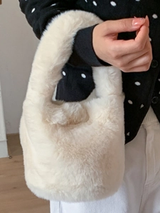 Chic cream white plush bucket bag made of soft faux fur with wide handles for autumn