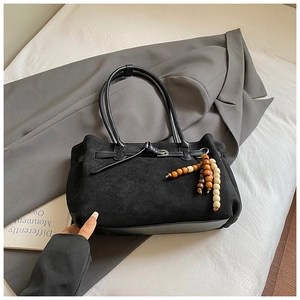 Dettaglio della borsa tote in pelle scamosciata nera con base in pelle e perline