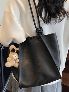 Minimalist black pebble leather tote bag for women with cute bear charm and shoulder strap